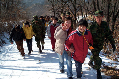 군장병들과 봉사자들이 장애우와 함께 산에 오르고 있다. 